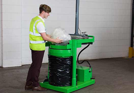 phs waste kit staff member filled a green compactor with plastic wrapping waste